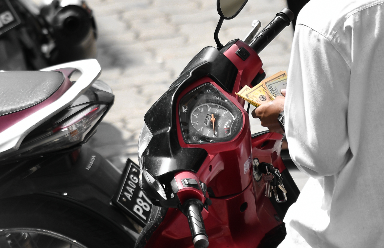 ޑޮލަރުތަކެއް މާރުކުރުމަށް ސައިކަލުގައި މަޑުކޮށްލައިގެން -- ފޮޓޯ: މިހާރު