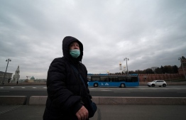 A woman wearing a protective face mask walks along a bridge in Moscow on October 27, 2021. - Russia reported on October 23, 2021 a record 1,075 Covid-19 deaths in 24 hours as Europe's hardest hit country with dramatically low vaccination rates braces for nationwide curbs from next week. -- Photo: Yuri Kadobnov / AFP