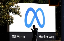 (FILE)  A pedestrian walks in front of a new logo and the name 'Meta' on the sign in front of Facebook headquarters on October 28, 2021 in Menlo Park, California. A new name and logo were unviled at Facebook headquarters after a much anticipated name change for the social media platform: Meta is amongst the companies with over 45 million followers that the Digital Services Act applies to since August of this year. -- Photo: Justin Sullivan/Getty Images