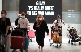 (FILE) Families walk out of the arrivals hall at Sydney's International Airport on November 1, 2021, as Australia's international border reopened almost 600 days after a pandemic closure began: Twenty months after Australia closed their borders in March 2020 . (Photo by Saeed Khan / AFP)