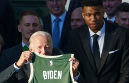 US President Joe Biden poses with Giannis Antetokounmpo (R) after he was presented with a jersey during an event honoring the 2021 NBA Championship Milwaukee Bucks on the South Lawn of the White House in Washington, DC on November 8, 2021.. -- Photo : Mandel Ngan/ AFP