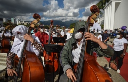 Members of the National System of Orchestras of Venezuela play during an attempt to enter the Guinness Book of Records for the largest orchestra in the world, with more than 12,000 musicians, at the Military Academy of the Bolivarian Army in Fuerte Tiuna Military Complex, in Caracas, on November 13, 2021. -- Photo: Federico Parra / AFP