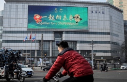 A message that reads "Together for a Shared Future", the slogan for Beijing 2022 Olympic and Paralympic Games, is seen on an outdoor screen of a shopping mall in Beijing on November 18, 2021: China is on high alert for coronavirus ahead of the 2022 Olympic Games -- Photo: Jade Gao/ AFP