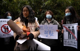 (FILES) In this file photo taken on December 2, 2020, Zhou Xiaoxuan (front), a feminist figure who rose to prominence during China’s #MeToo movement two years ago, stands amongst her supporters as she arrives at the Haidian District People’s Court in Beijing, in a sexual harassment case against one of China's best-known television hosts. China's #MeToo movement has stumbled in the face of swift internet censors, a patriarchal society and a legal system that places a heavy burden on the claimant.
