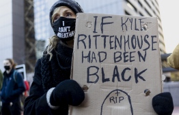 Demonstrators hold signs as they march in protest of the not guilty verdict in Kyle Rittenhouse's murder trial in Chicago, Illinois, November 20, 2021. -- Photo: Kamil Krzaczynski / AFP