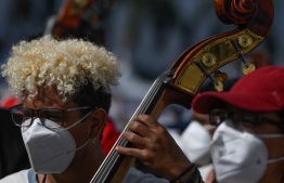 A member of the National System of Orchestras of Venezuela plays during an attempt to enter the Guinness Book of Records for the largest orchestra in the world, with more than 12,000 musicians, at the Military Academy of the Bolivarian Army in Fuerte Tiuna Military Complex, in Caracas, on November 13, 2021. (Photo by Federico PARRA / AFP)