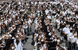 Members of the National System of Orchestras of Venezuela play during an attempt to enter the Guinness Book of Records for the largest orchestra in the world, with more than 12,000 musicians, at the Military Academy of the Bolivarian Army in Fuerte Tiuna Military Complex, in Caracas, on November 13, 2021. -- Photo: Federico Parra / AFP