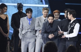 This handout photo courtesy of American Broadcasting Companies, Inc. / ABC shows (L-R) J-Hope, V, RM, Jimin, Suga, and Jungkook of South Korean band BTS accept the Artist of the Year award onstage during the 2021 American Music Awards at the Microsoft Theater on November 21, 2021 in Los Angeles. (Photo by American Broadcasting Companies, Inc. / ABC / AFP) / 