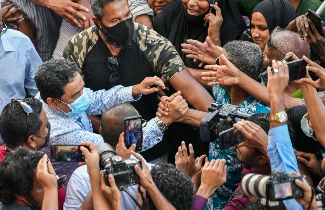 ނޮވެމްބަރު 30، 2021- ކުރީގެ ރައީސް ޔާމީނަށް ކްރިމިނަލް ކޯޓުން ކުރި ހުކުމް ސުޕްރީމް ކޯޓުން މިއަދު ބާތިލުކުރުމުން، އެ މަނިކުފާނު ގެކޮޅަށް ވަޑައިގަންނަވާނެ އިރެއްގެ އިންތިޒާރުގައި އެއްވެ ތިބި ސަޕޯޓަރުންނާ ސަލާމް ކުރައްވަނީ: ޔާމީންގެ މި ކާމިޔާބީއަކީ އެ މީހުން ދެކޭގޮތުގައި މުޅި ގައުމަށް ލިބުނު ތާރީހީ ނަސްރެއް.---ފޮޓޯ: ފަޔާޒު މޫސާ/ މިހާރު