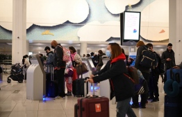Travelers wear masks at LaGuardia International Airport on November 30, 2021 in New York, New York as concern grows worldwide over Omicron, the newest Covid-19 variant. -- Photo: Robyn Beck / AFP