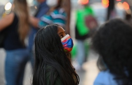 A girl wearing a protective face mask visits Hollywood Boulevard in Hollywood, California, December 1, 2021: the mask mandate brought into effect in California on Monday is applicable to vaccinated and unvaccinated individuals -- Photo: Robyn Beck / AFP