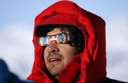 Handout picture released by Imagen Chile showing a Chilean scientist looking at a total solar eclipse from Union Glacier in Antarctica, on December 4, 2021. -- Photo:
 Felipe Trueba / Imagen Chile / AFP