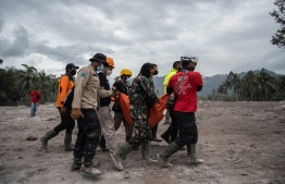 Rescuers carry away a body of a victim at Sumber Wuluh village in Lumajang on December 6, 2021, after the Semeru volcano eruption that killed at least 14 people. -- Photo: Juni Kriswanto / AFP