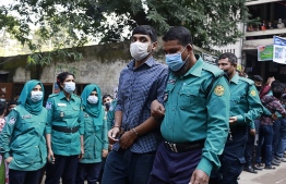 Police escort one of the 20 convicted university students, after their sentence to death for the brutal 2019 murder of a young man who criticised the government on social media, out of a court in Dhaka on December 8, 2021. -- Photo: AFP