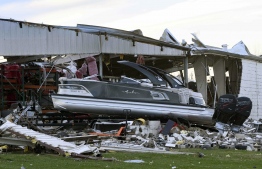 A boat sits at rest after being sucked out of a marine dealership by a tornado in Mayfield, Kentucky, on December 11, 2021. - Tornadoes ripped through five US states overnight, leaving more than 70 people dead Saturday in Kentucky and causing multiple fatalities at an Amazon warehouse in Illinois that suffered "catastrophic damage" with around 100 people trapped inside. The western Kentucky town of Mayfield was "ground zero" of the storm -- a scene of "massive devastation," one official said. -- Photo: John Amis / AFP