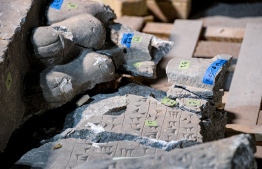 This picture taken on December 14, 2021 shows a fragment of an artefact bearing cuneiform inscriptions being reconstructed and reassembled at the Mosul Museum in Iraq's northern city. - In the damaged Mosul Museum, Iraqis supported by French restoration workers sort through the fragments of 2,500-year-old remains destroyed by jihadists, part of efforts aiming for reconstruction. -- Photo: Zaid Al-Obeidi/ AFP