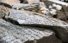 This picture taken on December 14, 2021 shows a fragment of an artefact bearing cuneiform inscriptions being reconstructed and reassembled at the Mosul Museum in Iraq's northern city. - In the damaged Mosul Museum, Iraqis supported by French restoration workers sort through the fragments of 2,500-year-old remains destroyed by jihadists, part of efforts aiming for reconstruction. -- Photo by Zaid Al-Obeidi/ AFP