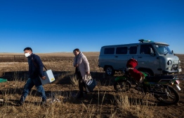 This picture taken on December 13, 2021 shows health workers Enkhjargal Purev (R) and Sodkhuu Galbadrakh delivering  Covid-19 coronavirus vaccines for herders in Delgertsogt county, in Mongolia's Dundgobi province. -- Photo: Byambasuren Byamba-Ochir / AFP