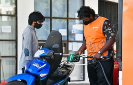 A petrol pump attendant refills gas at a Fuel Supplies Maldives refueling station; a subsidiary of STO-- Photo: Fayaz Moosa | Mihaaru