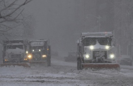 Trucks plow snow during a winter storm over the capital region on January 3, 2022 in Washington, DC. - After a bruising holiday week of flight cancellations and record surges in Covid-19 cases, a powerful winter storm Monday further snarled US transport and shuttered the federal government and schools. A winter storm hammered the capital and other parts of the mid-Atlantic, with official forecasts of five to 10 inches (12.7 to 25.4 centimeters) of snow in Washington. -- Photo: Pablo Porciuncula/ AFP