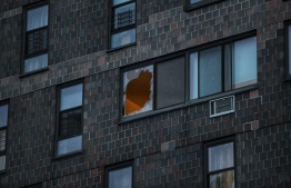 A broken window is seen at an apartment building after a deadly fire in the Bronx, on January 9, 2022, in New York. -- Photo: Ed Jones / AFP