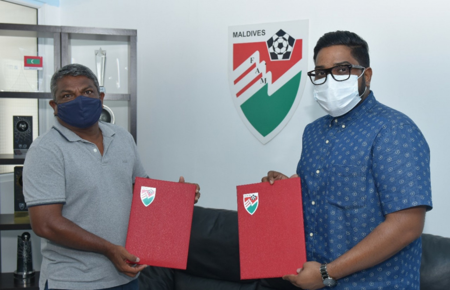 ފުޓްބޯޅަ ސީޒަންގެ 2020-2021 ގެ ސީޒަނަށް، ކްލަބްަކަށް އެފްއޭއެމުން ފައިސާ ދިނުމަށް، އެއްބަސްވުމުގައި ސޮއިކުރުމަށް ބޭއްވި ރަސްމިއްޔާތުގެ ތެރެއިން: އެފްއޭއެމްގެ ރައީސް ބައްސާމް (ކ) އަދި މާޒިޔާގެ ޗެއާމަން އަހްމަދު ސާޖިދު (ވ) އެއްބަސްވުން ހިފައިގެން ފޮޓޯއަކަށް ހުއްޓިލައިގެން --- ފޮޓޯ: އެފްއޭއެމް