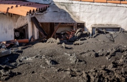 This photograph taken on January 4, 2022 shows a house damaged by the lava flow following the Cumbre Vieja volcano's eruption, on the Spanish Canary Island of La Palma. - The eruption of the Cumbre Vieja began on September 19 and was officially declared over on December 25, after 10 days of inactivity. The lava destroyed more than 1,300 houses, and 1,250 hectares of land, many of which were cultivated with bananas, avocados or vines. -- Photo: Desiree Martin / AFP