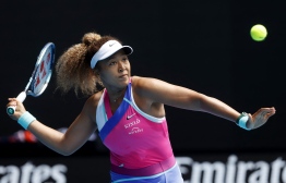 Japan's Naomi Osaka hits a return against Colombia's Camila Osorio during their women's singles match on day one of the Australian Open tennis tournament in Melbourne on January 17, 2022. (Photo by Brandon MALONE / AFP) / 