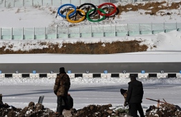 Workers prepare the biathlon shooting range in Zhangjiakou on January 15, 2022 ahead of the Beijing 2022 Winter Olympics. -- Photo:  François-Xavier Marit / AFP