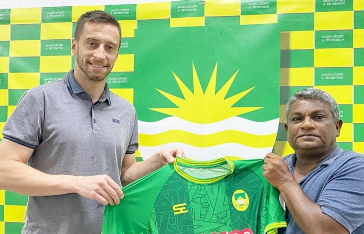 މާޒިޔާގެ ޗެއާމަން އަހްމަދު ސާޖިދު (ކ) އާއި އެޓީމަށް އަލަށް ސޮއިކުރުވި ޑިފެންޑަރު ކާޓަލް މާޒިޔާގެ ޖޯޒޯ ހިފަހައްޓާލައިގެން --- ފޮޓޯ: މާޒިޔާ