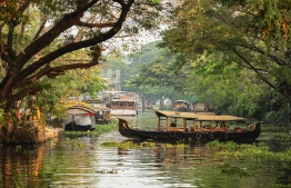 Beautiful backwaters landscape in Alleppey city with traditional houseboats at sunset in Kerala, India