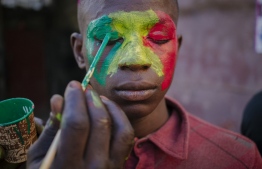 A supporter of Senegal national football team gets his face painted in Dakar on January 6, 2022, before the final match of the Africa Cup of Nation (CAN) against Egypt in Yaounde, Cameroon. -- Photo: Carmen Abd Ali/ AFP