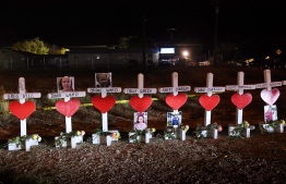 (FILES) In this file photo taken on November 8, 2017 crosses with the names of victims are seen outside the First Baptist Church which was the scene of the mass shooting that killed 26 people in Sutherland Springs, Texas. - A US federal judge on February 7, 2022 ordered the Air Force to pay more than $230 million in damages to survivors and relatives of victims of a 2017 Texas shooting for failing to report the perpetrator's criminal record. -- Photo: Mark Ralston / AFP