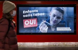 An electoral placard reads in French: "Children without tobacco, YES" in Lausanne on February 8, 2022. - The Swiss will vote on February 13, 2022 on whether to tighten their notoriously lax tobacco laws by banning virtually all advertising of the health-hazardous products. -- Photo: Valentin Flauraud / AFP