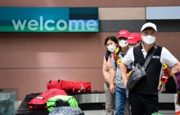 (FILES) This file photo taken on November 20, 2021 shows South Korean tourists waiting for their luggage at Phu Quoc international airport, as the Vietnamese island welcomed its first international tourists following a Covid-19 coronavirus vaccine passport scheme. - Vietnam will lift coronavirus restrictions on international passenger flights from February 15, 2022, the country's aviation authority said in a statement. -- Photo:  Nhac Nguyen/ AFP