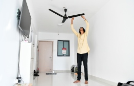 ހަމްދާން އޭނާ މިހާރު ދިރިއުޅޭ ހިޔާ ފްލެޓްގެ އެޕާޓްމަންޓްގެ ލިވިންރޫމުގައި ހުރެގެން ސީލިންގު ފަންކާއެއް ފޮޅައި ސާފުކޮށްލަނީ. --މިހާރު ފޮޓޯ