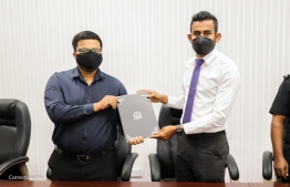 Commissioner of Prisons Ahmed Mohamedfulhu (R) and Managing Director of Zeta Technology Mohamed Aiman Adam showing the agreement signed between them as they are photographed, on February 17 -- Photo: MCS