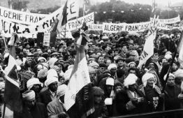 Algerian people carry banners demanding that Algeria remains French, on December 09, 1960 in front of the town hall of Aïn Temouchent, the first stage of French President General Charles de Gaulle's trip to Algeria. -- Photo: AFP