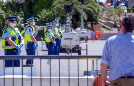 Police offices stand guard in front of the parliament as anti-vaccine demonstrators occupy the grounds nearby in Wellington on February 22, 2022. -- Photo: Dave Lintott / AFP