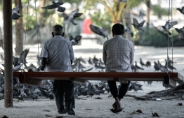 Two older gentlemen sitting on a Maldivian style swing called un'dhoali -- Photo: Nishaan Ali / Mihaaru