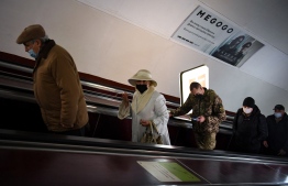People ride an escalator at a metro station in Kyiv early on February 24, 2022. - Russian President Vladimir Putin announced a military operation in Ukraine on Thursday with explosions heard soon after across the country and its foreign minister warning a "full-scale invasion" was underway. (Photo by Daniel LEAL / AFP)