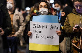 People protest with a placard 'Swift out for Russia' against Russia's invasion of Ukraine in Dortmund, western Germany on February 25, 2022. -- Photo: Ina Fassbender / AFP