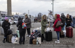 Ukrainian citizens are seen arriving at the Medyka pedestrian border crossing fleeing the conflict in their country, in eastern Poland on February 27, 2022. - As Ukraine braces for a feared Russian invasion, its EU member neighbours are making preparations for a possible influx of hundreds of thousands or even millions of refugees fleeing military action. (Photo by Wojtek RADWANSKI / AFP)