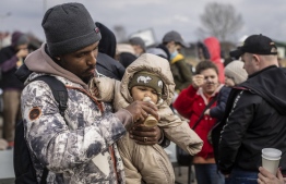 Refugees from many different countries - from Africa, Middle East and India - mostly students of Ukrainian universities are seen at the Medyka pedestrian border crossing fleeing the conflict in Ukraine, in eastern Poland on February 27, 2022. - As Ukraine braces for a feared Russian invasion, its EU member neighbours are making preparations for a possible influx of hundreds of thousands or even millions of refugees fleeing military action. (Photo by Wojtek RADWANSKI / AFP)