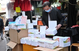 A vendor arranges Covid-19 test kits for sale on a street in Hong Kong on February 25, 2022, as yet another record high number of new Covid-19 infections were recorded in the city. -- Photo: Peter Parks / AFP