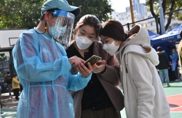 People check in at a Covid-19 testing centre in Hong Kong on February 25, 2022, as yet another record high number of new Covid-19 infections were recorded in the city. -- Photo: Peter Parks / AFP