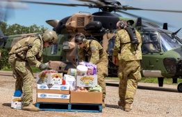 A handout photo taken on March 4, 2022 and released by Australian Defence Force on March 6, shows Australian Army soldiers loading crates of fresh food onto an MRH-90 Taipan Multi Role Helicopter, ready for delivery to areas of Northern New South Wales affected by Floods. -- Photo: Dustin Anderson / Australia Defence Force / AFP