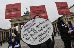 (FILES) In this file photo taken on November 25, 2021 A protester holds up a sign reading "My Body my choice- the right to abortion" during a demonstration against violence against women called by women's right organisation "Terre des Femmes" in front of the Brandenburg Gate in Berlin, on November 25, 2021. - After years of controversy and criticism from gynaecologists, Germany is planning to scrap a Nazi-era law that limits information on abortion, while access to the procedure in the country remains beset by obstacles. -- Photo: John Macdougall / AFP