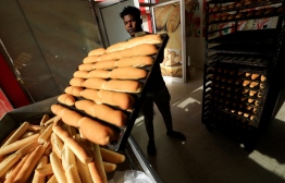 An employee prepares bread at a bakery in the Sudanese capital Khartoum on March 17, 2022. - Sudanese people have suffered for decades severe economic hardship due to government mismanagement, internal conflicts, and the 2011 secession of the oil-rich south. Prices have seen several hikes since the 2019 ouster of president Omar al-Bashir. -- Photo: Ashraf Shazly / AFP