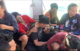 This handout photo from Search and Rescue (SAR) team and taken on March 19, 2022 and released on March 20, 2022 shows migrants workers sitting on a boat during a rescue operation at sea in North Sumatra water where two people died and 26 others are missing after a ferry carrying dozens of migrants sank off the coast of Indonesia. -- Photo: Handout / search and Rescue / AFP